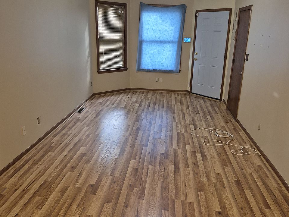 Living room: new flooring. View from dining room through living room to front door.