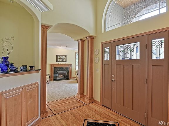 Light and bright entry includes a heated shoe cabinet, vaulted ceilings and ornate hardwood flooring!