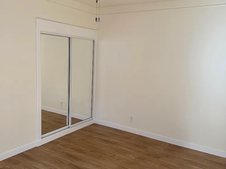 East bedroom closet with mirrored doors.