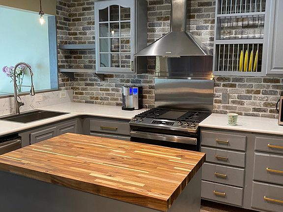 Kitchen view #2 Island contains roll-out trash rack + Bottom cabinet with shelves.