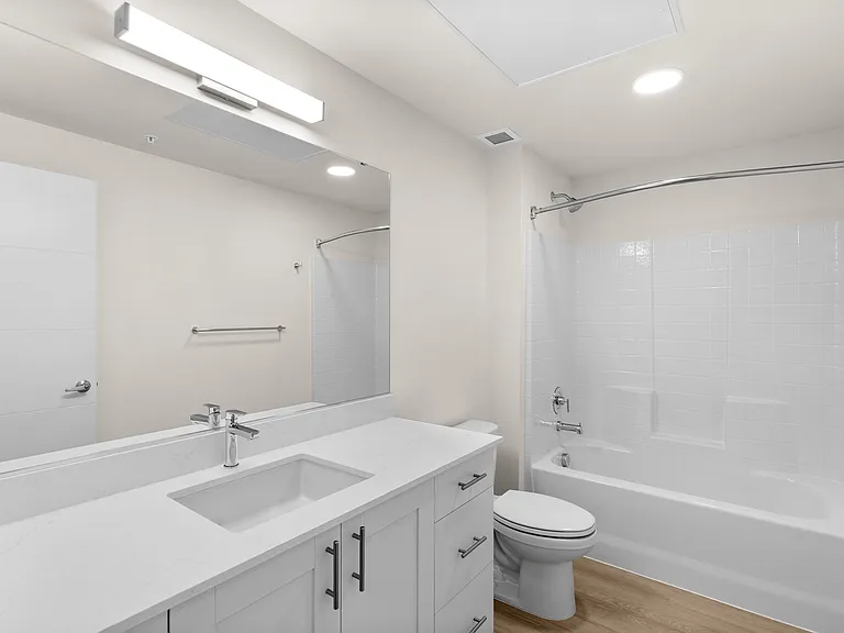 Fresh, modern apartment bathroom featuring a walk-in tub, white tile, and a storage-rich vanity. Fresh, modern apartment bathroom featuring a walk-in tub, white tile, and a storage-rich vanity.