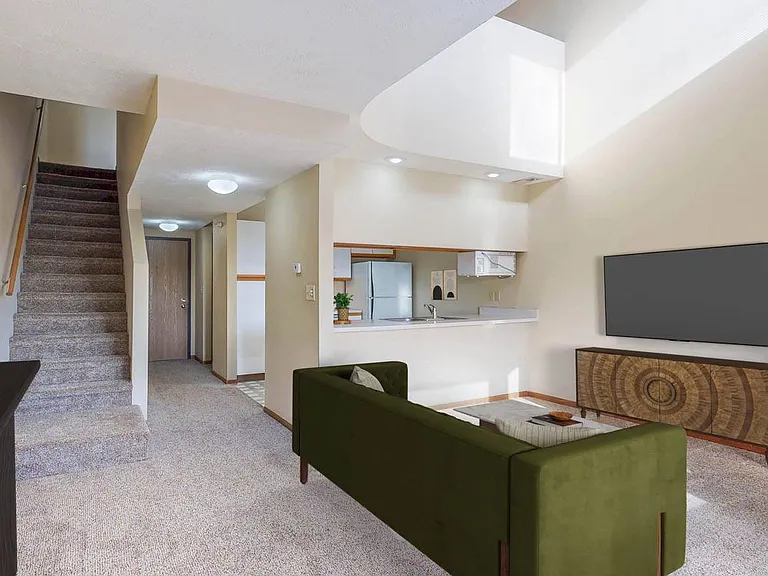 Enjoy the open feel of the Madison's multi-level layout, complete with cozy living space, a nearby kitchen pass-through, and a staircase leading up to the lofted bedroom.