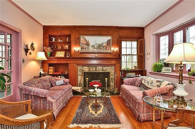 Large sunken living room with fireplace, large bow window, built in shelves.