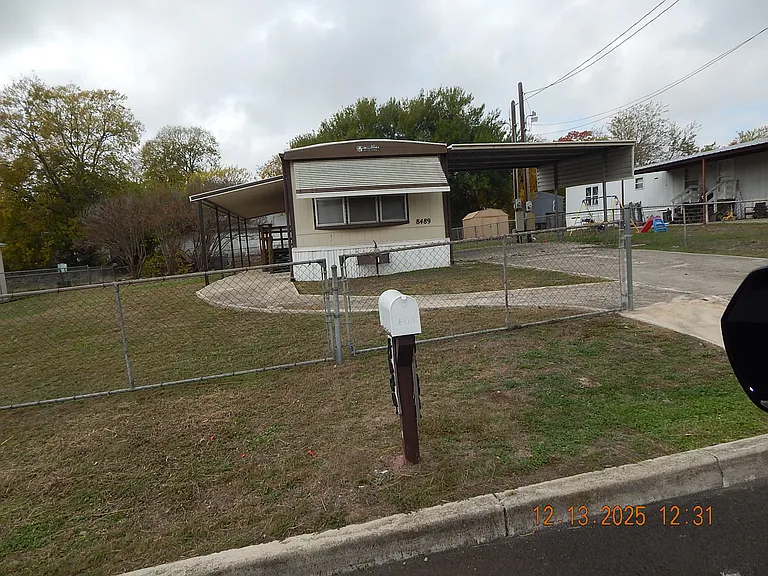 Photo taken to show direct front of home and large fenced lot.
