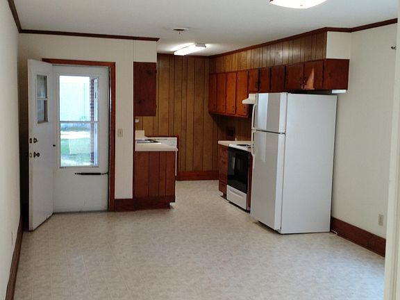 View looking from hallway through Dining room into Kitchen. Door to carport is on the left. Nice storm door units on front and back doors.