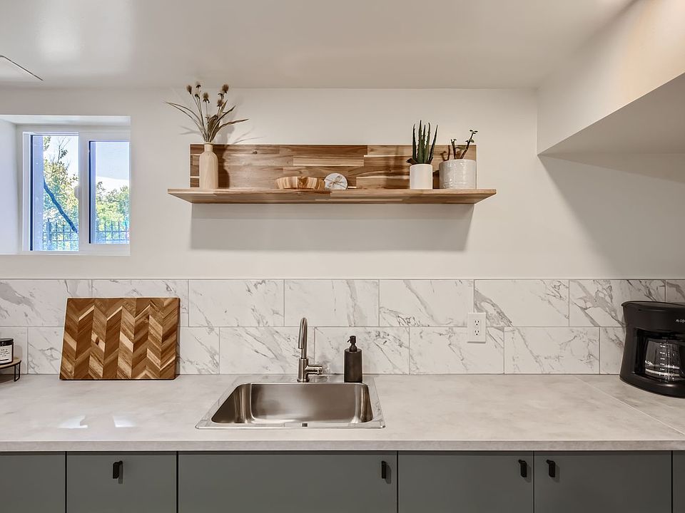 Spacious kitchen with sage green, deep storage cabinets + functioning window for natural light and fresh air.