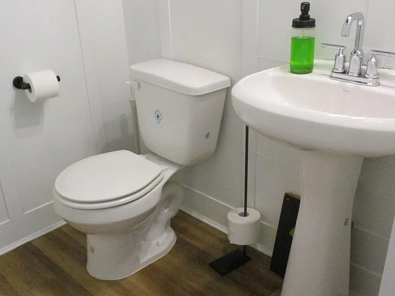 powder room downstairs with herringbone w/ wainscoting