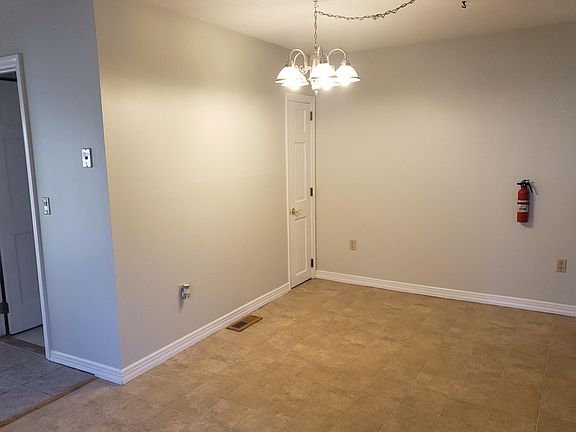 View of dining area from kitchen. Bathroom door on the left, small storage closet in the center. Fire extinguisher.