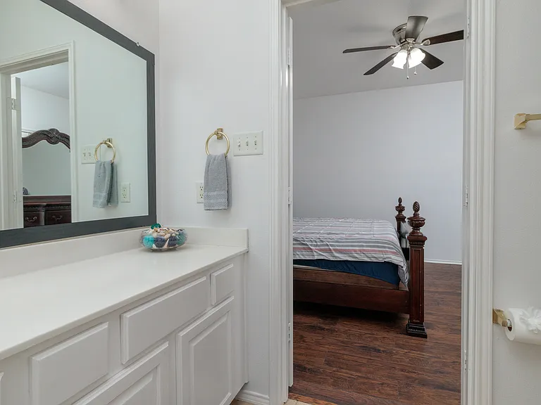 Attached Primary bathroom with bathtub/shower combo with large mirror and sink.