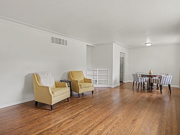 Main level living/dining room with fireplace and built in bookshelf.