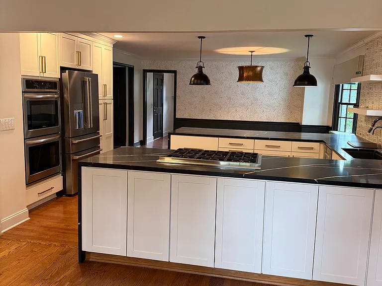 Kitchen features high end appliances and stone waterfall edge countertops