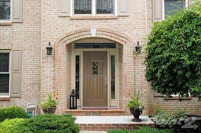 Lush landscaping surrounds this beautiful home. Custom brick work and leaded glass sidelights and window enhance the inviting entrance.