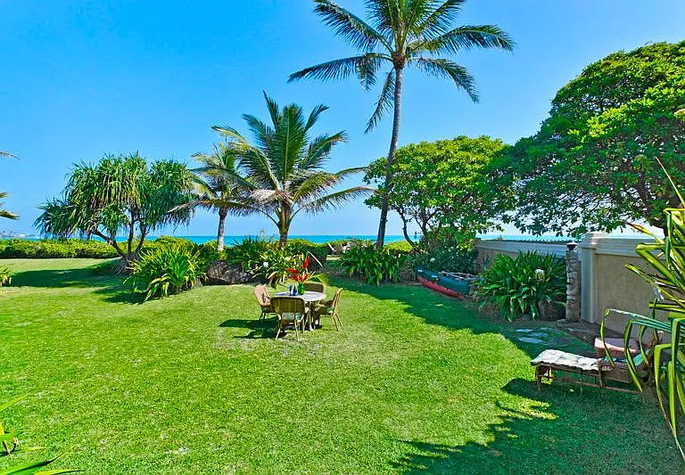 Big grassy lawn leads you to miles of sandy beach just beyond your door.