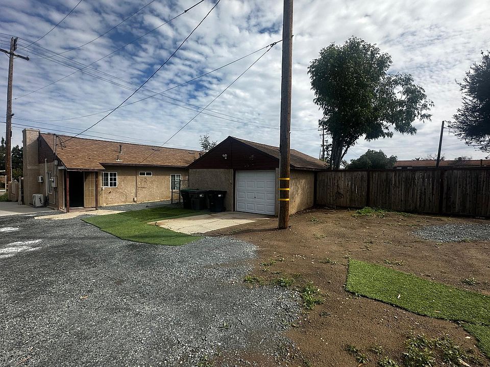 Photo for the back yard showing detached garage and entrance to the kitchen.