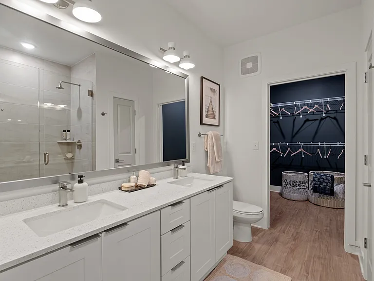 Bathroom with Quartz Countertops, Double Vanity Sinks, Walk-in Shower, and Walk-in Closet