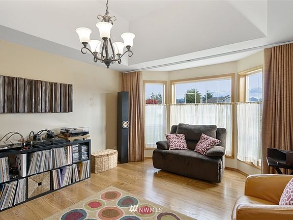 Living Room. The bay window has divided lights to give the front elevation a high-end look. A bounty of natural light! (Seller is keeping the mounted brown curtains, but all other window treatments in the home stay!)
