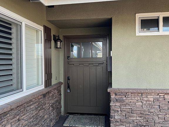 Front of home with custom stack stone and 3/4 split door