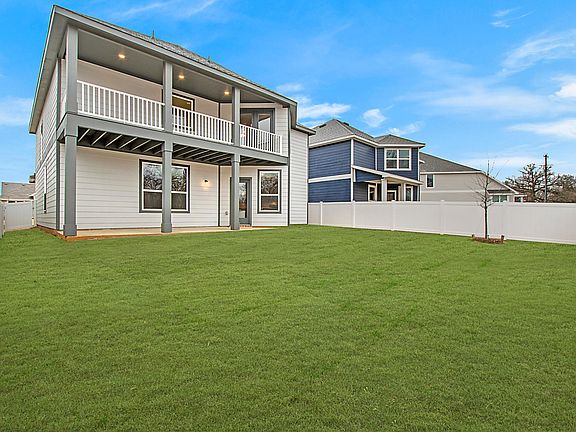 Look at the back of this home... Love the balcony off of the primary bedroom.