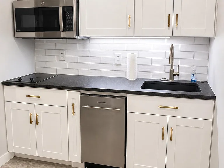 The kitchen is thoughtfully designed with ample storage, great counter space, a dishwasher, two cooktop burners, and a convection microwave that doubles as an oven, everything you need to cook comfortably and efficiently.
