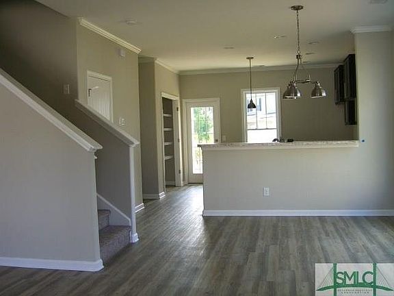 VIEW FROM FRONT ENTRY OF DINING ROOM, KITCHEN WITH BREAKFAST BAR