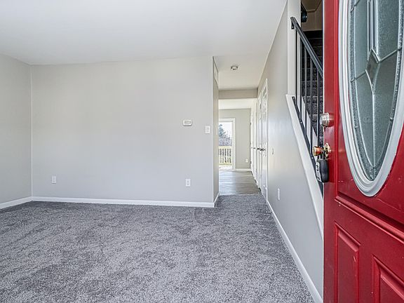 An open concept living room leads into the kitchen/dining area, where a half bath and laundry are conveniently located.