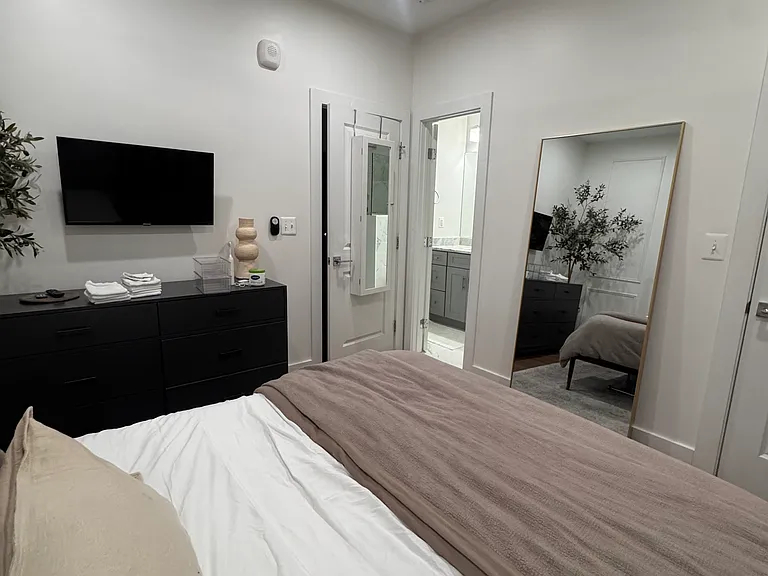The primary bedroom features a 30-inch wall-mount flat screen tv
