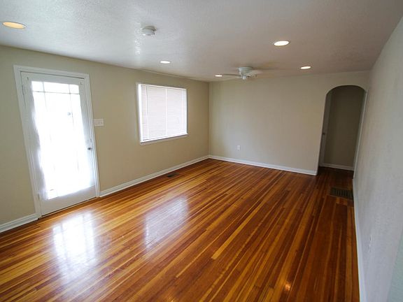 Living Room, North Wall: Ceiling fan and recessed lighting, glass framed front door, picture window, entry to bedrooms