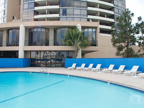 Outdoor swimming pool with sundeck and lounge seating.