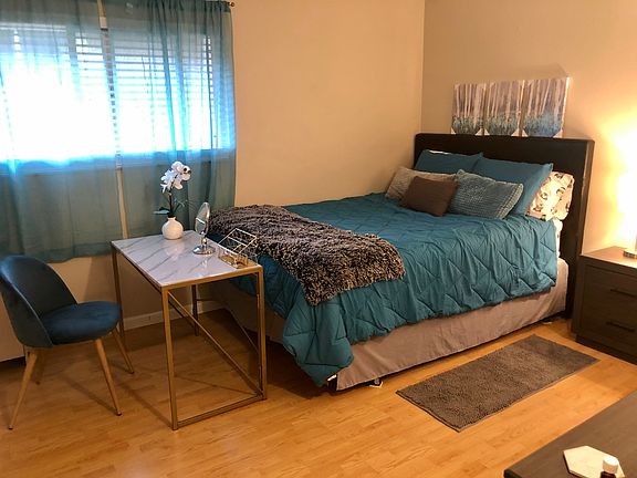 Big bedroom with lovely light wood floors and lots of storage in six drawer mirrored dresser, two drawer nightstand and big walk in closet.