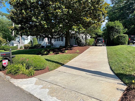 Long driveway to more parking and two-car carport behind gate.