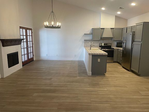View from the front door, kitchen and dining room with fireplace. French doors give access to the back patio that has a grill.
