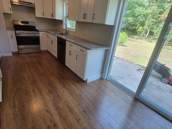 white kitchen with granite countertops, new dishwasher and gas stove
