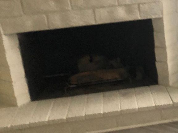 Brick wall that encompasses a floor to ceiling fireplace in the living/family room