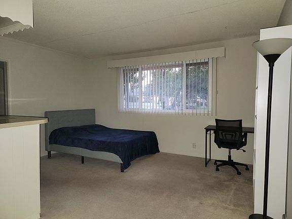view from front door (queen size bed, desk, chair, and bookcase shown to give size; no furniture included)