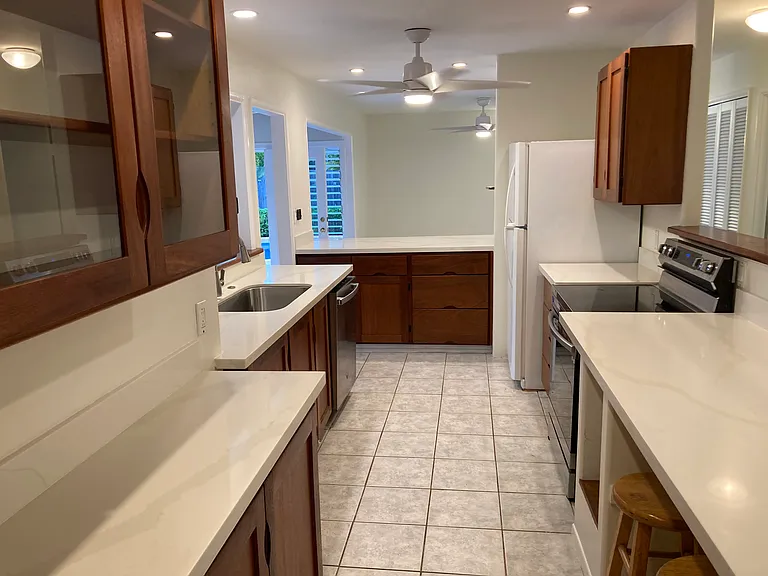 Kitchen has a cubby for a wine refrigerator.