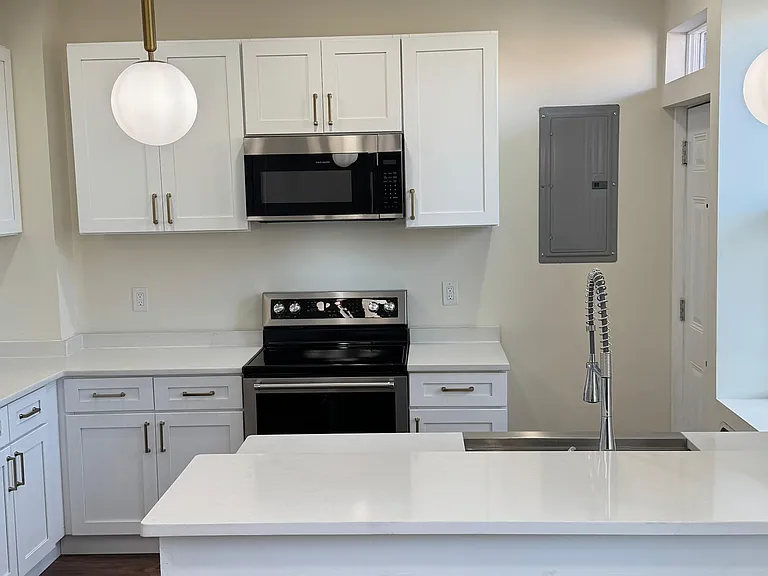 Modern kitchen with granite countertops, island seating, and updated appliances