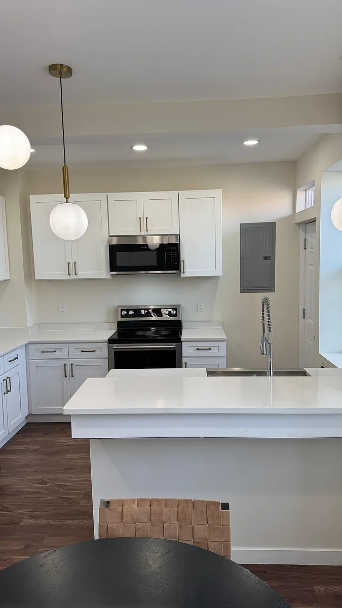Modern kitchen with granite countertops, island seating, and updated appliances - 6309B Delmar Blvd #3E