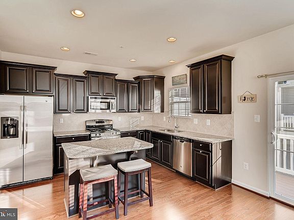 Kitchen with island, stainless appliances, and granite countertops.