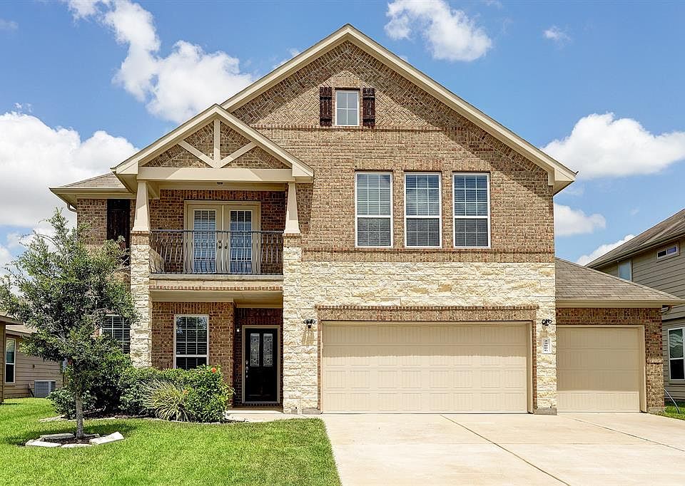 Beautiful stone and brick home with covered front porch and double door upper balcony with wrought irons rails. Home has an extended 3 Full Garage. LOW TAX area!
