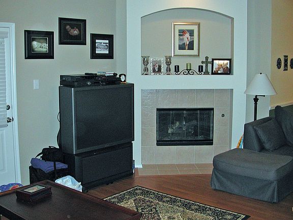 Large family room has wood flooring and opens to kitchen.