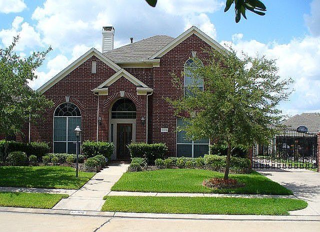 Front of house with cast iron landscaping fence and gas lantern.