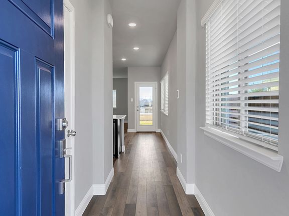 Corridor with a healthy amount of sunlight and dark wood-type flooring
