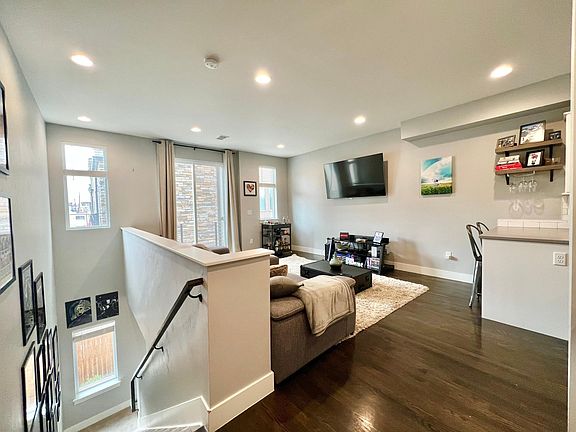 Spacious living room with hardwood floors and open to kitchen, perfect for entertaining.