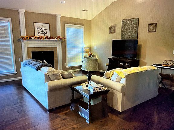 Beautiful Vaulted Living Room features Wood-Laminate Flooring and Cozy Gas Fireplace