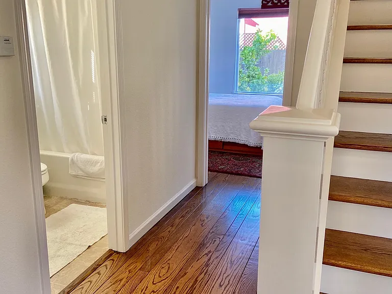 Hall way with first bathroom and downstairs bedroom in back.