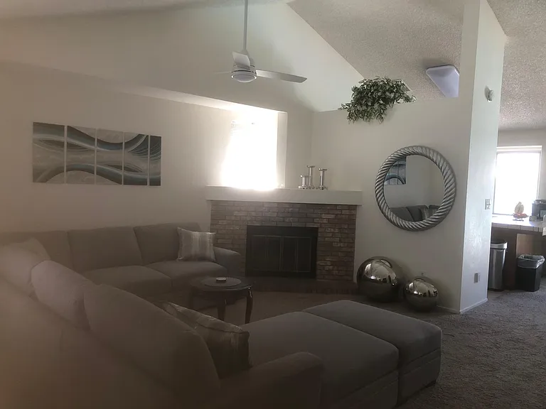 Living room with gray sectional and huge Smart TV with Netflix app