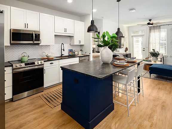 Open-Concept Kitchen with Pendant Lighting and Stainless Steel Appliances