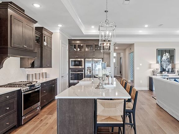 Kitchen with island, pendant lighting and glass-front upper cabinets