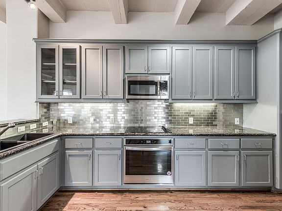 Recently painted kitchen cabinets and stainless subway tile, great kitchen storage and work space.