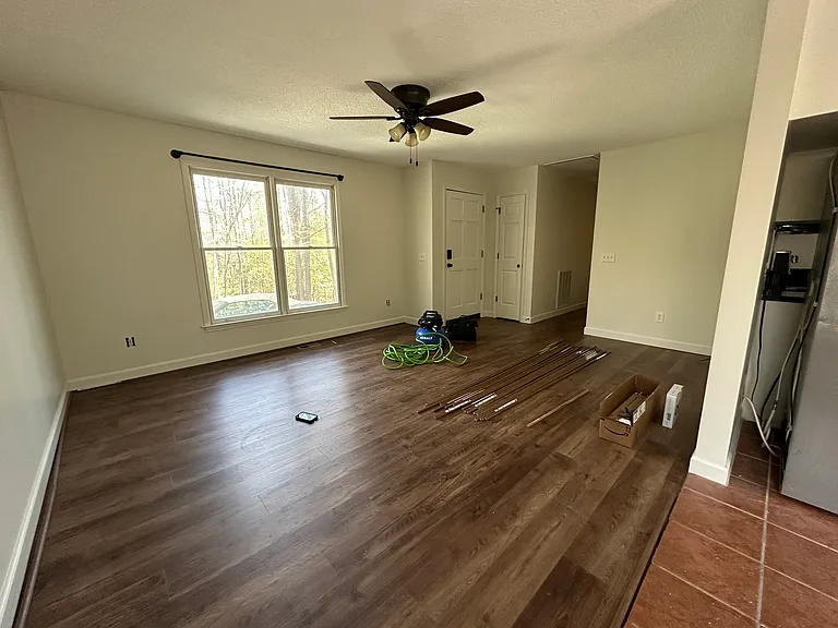 living room with new flooring, new fan, new curtain rods
